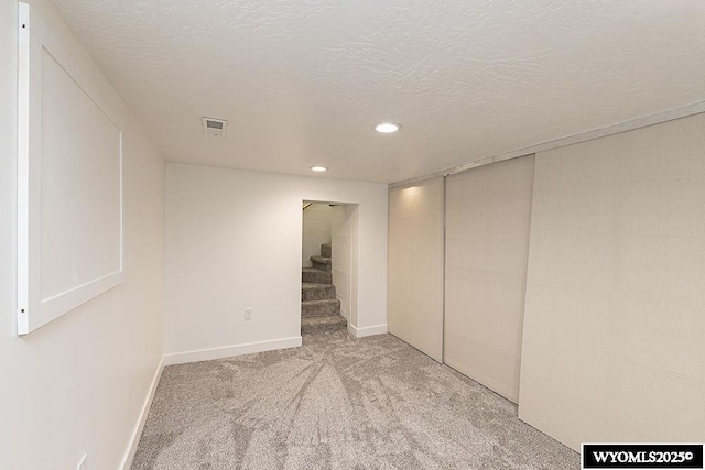 basement with light carpet and a textured ceiling