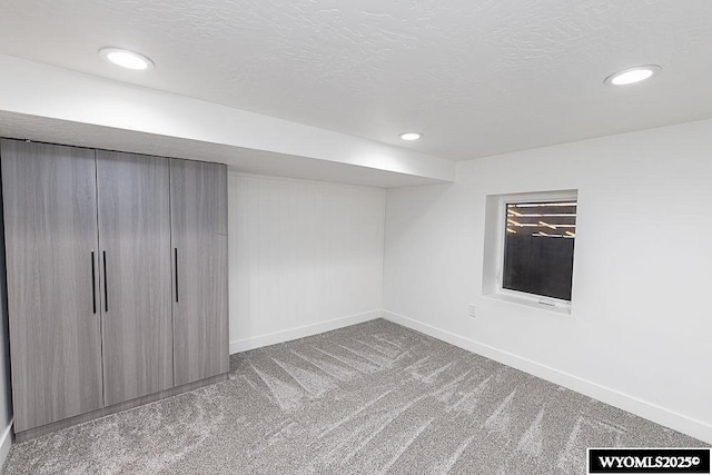 basement featuring carpet floors and a textured ceiling