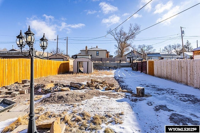 snowy yard featuring a shed