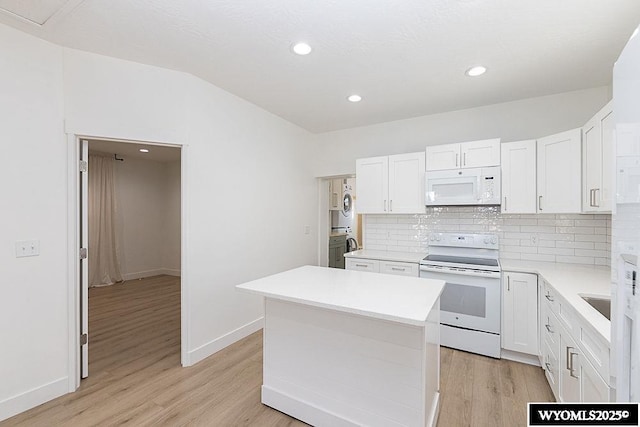 kitchen with white cabinetry, white appliances, tasteful backsplash, and a center island