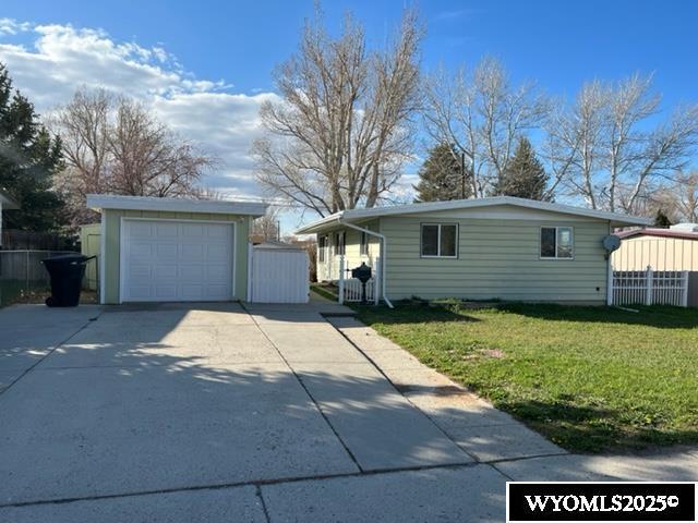 view of side of home featuring a garage, an outdoor structure, and a yard