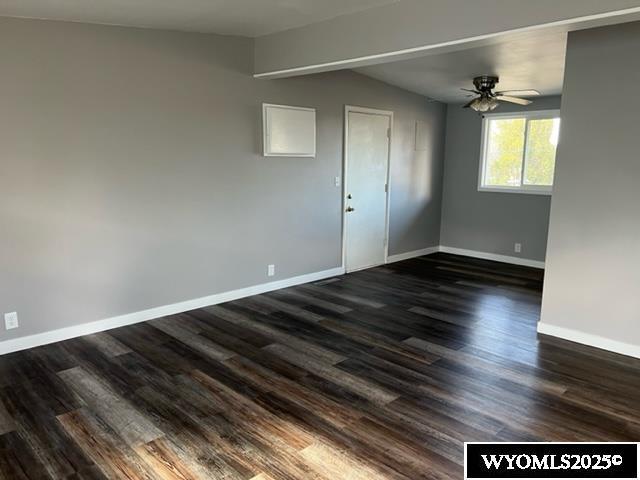 empty room featuring ceiling fan, lofted ceiling, and dark hardwood / wood-style floors