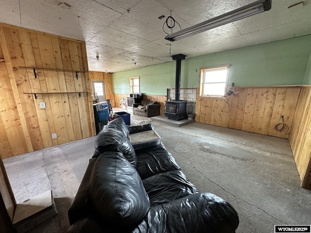 living room featuring wooden walls and a wood stove