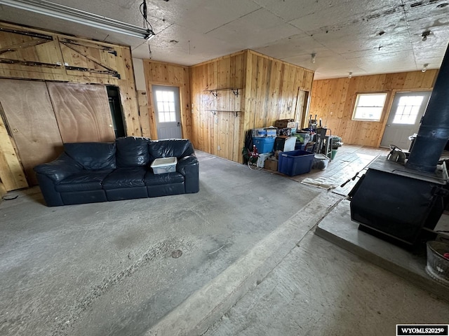 basement featuring wood walls and a wood stove