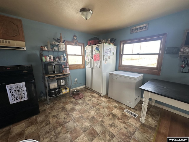 clothes washing area with a textured ceiling