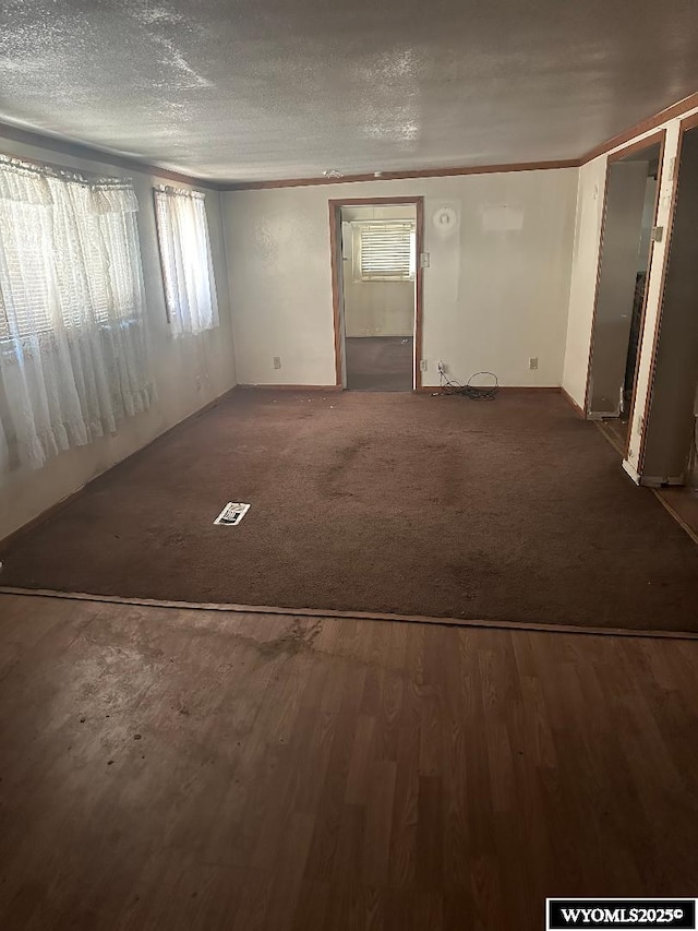 interior space featuring dark carpet and a textured ceiling