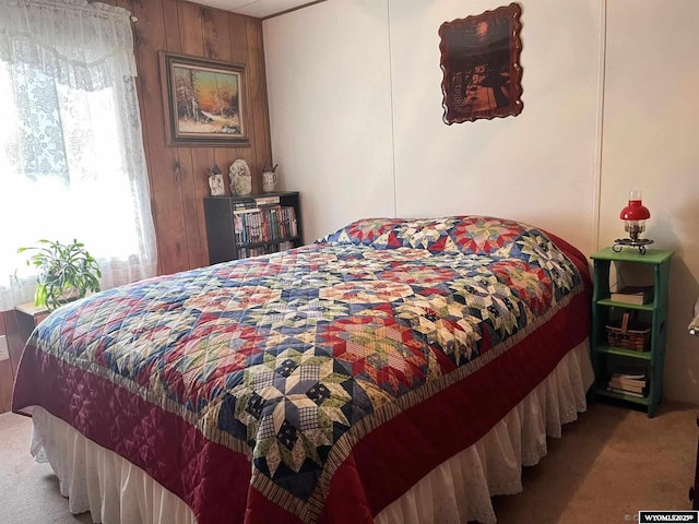 carpeted bedroom with wood walls