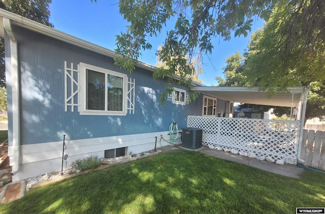 back of house featuring a lawn and central air condition unit