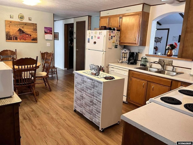 kitchen with sink, white appliances, and light hardwood / wood-style floors