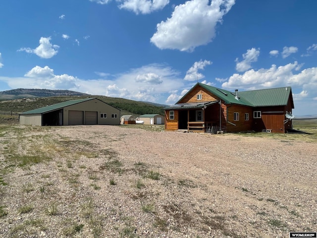 view of front of home with a garage, a mountain view, and an outbuilding