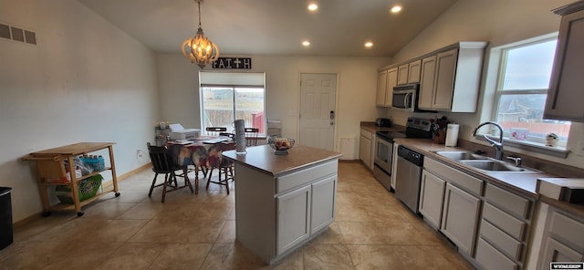 kitchen featuring gray cabinets, decorative light fixtures, sink, a center island, and stainless steel appliances