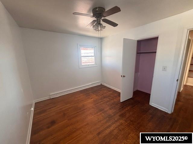 unfurnished bedroom with ceiling fan, dark hardwood / wood-style flooring, and a closet