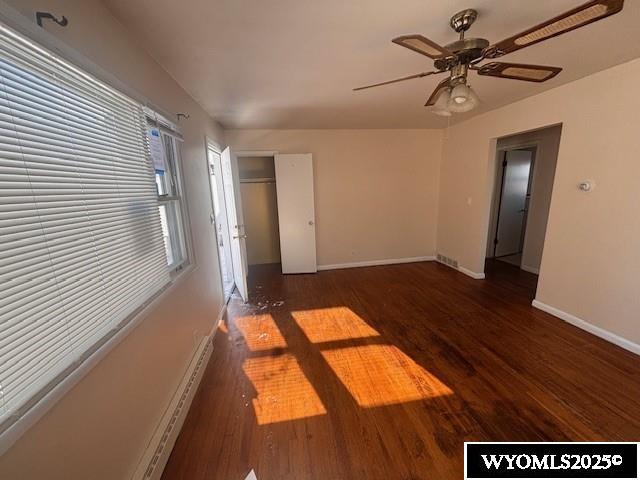 unfurnished room with ceiling fan and dark hardwood / wood-style flooring