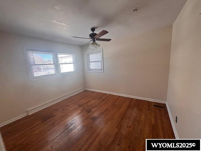 spare room with dark hardwood / wood-style floors and ceiling fan