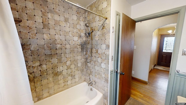 bathroom featuring hardwood / wood-style flooring and tiled shower / bath