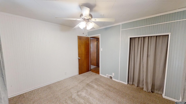 unfurnished bedroom featuring light colored carpet, ceiling fan, and a closet