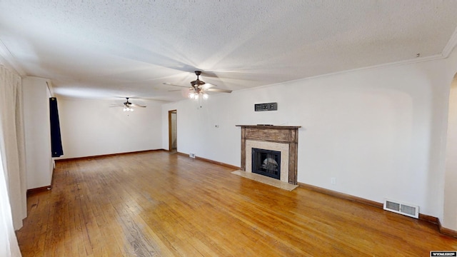 unfurnished living room with ceiling fan, wood-type flooring, and a textured ceiling