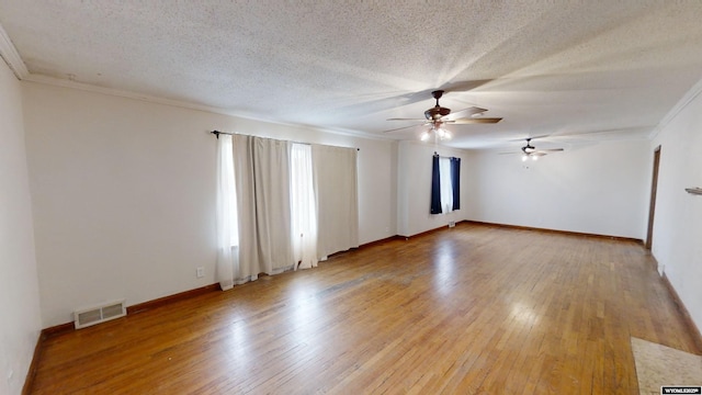 spare room featuring crown molding, wood-type flooring, and a textured ceiling