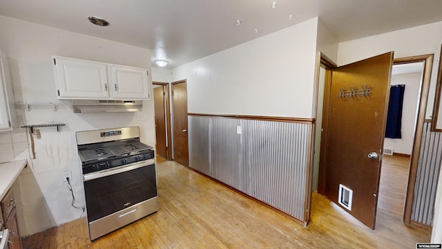 kitchen featuring white cabinetry, stainless steel gas range oven, and light hardwood / wood-style flooring