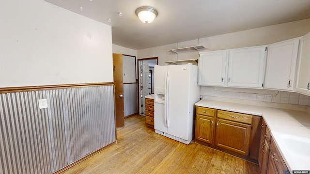 kitchen with white cabinetry, tasteful backsplash, white fridge with ice dispenser, and light wood-type flooring