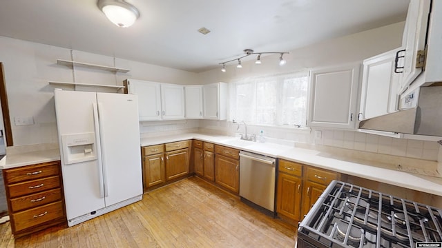 kitchen featuring dishwasher, sink, decorative backsplash, white refrigerator with ice dispenser, and light hardwood / wood-style floors