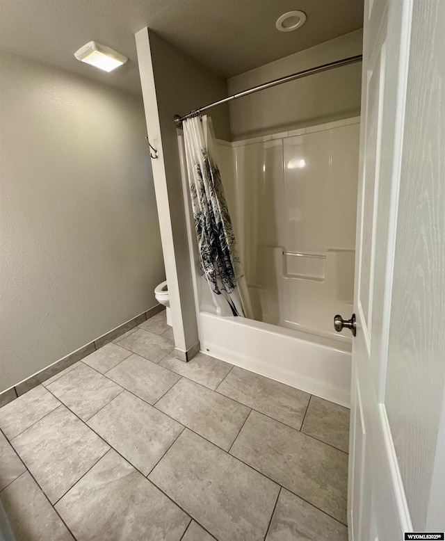 bathroom with tile patterned flooring, shower / bathtub combination with curtain, and toilet