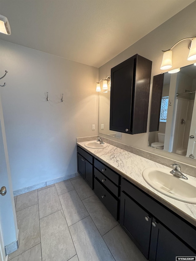 bathroom with a shower, vanity, and toilet