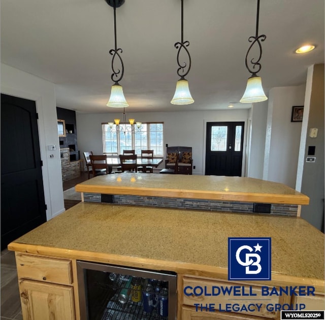 kitchen with wine cooler, decorative light fixtures, light brown cabinetry, and an inviting chandelier