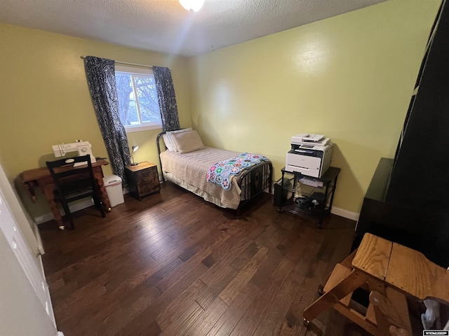 bedroom with dark hardwood / wood-style flooring and a textured ceiling