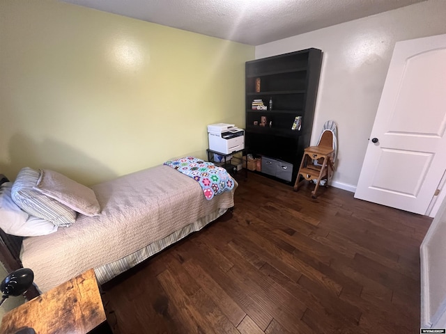 bedroom featuring dark hardwood / wood-style flooring and a textured ceiling