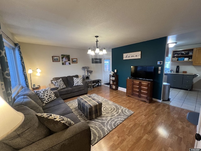 living room with a chandelier, hardwood / wood-style floors, and a textured ceiling