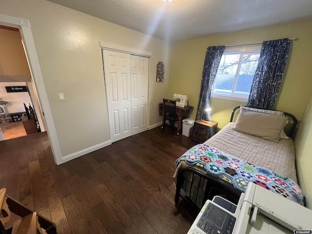 bedroom featuring dark wood-type flooring, a closet, and a textured ceiling