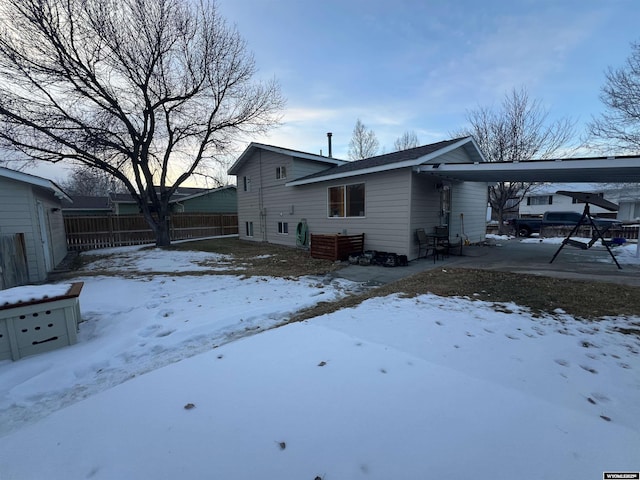 view of snow covered back of property