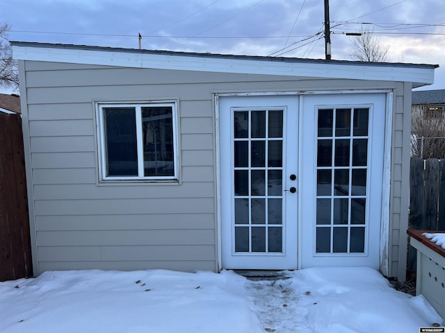 snow covered structure with french doors