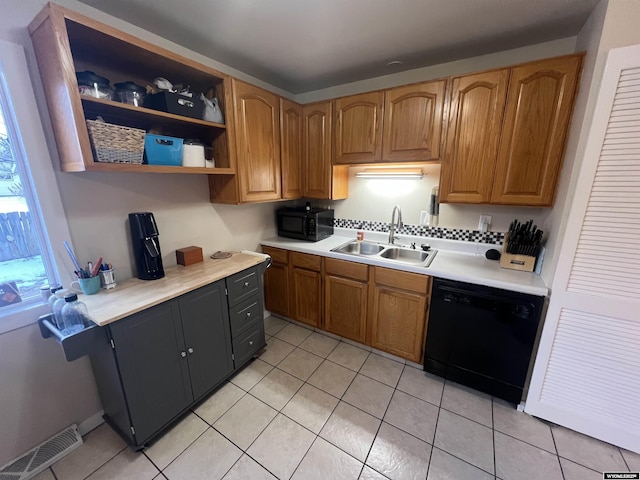 kitchen featuring light tile patterned flooring, sink, and black appliances