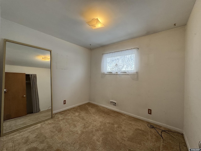 carpeted spare room featuring baseboards