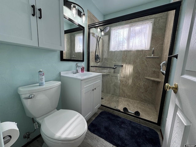 bathroom with toilet, vanity, and a tile shower