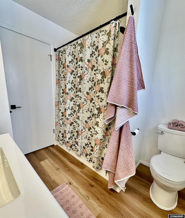 bathroom featuring hardwood / wood-style flooring, sink, a textured ceiling, and toilet