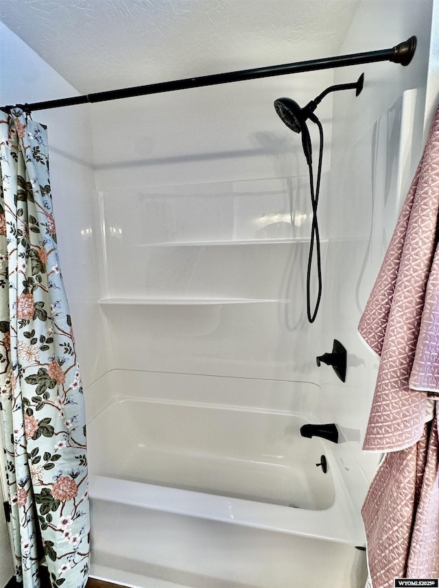 bathroom with shower / bath combination with curtain and a textured ceiling