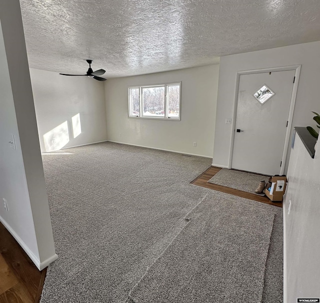 carpeted entrance foyer with ceiling fan and a textured ceiling