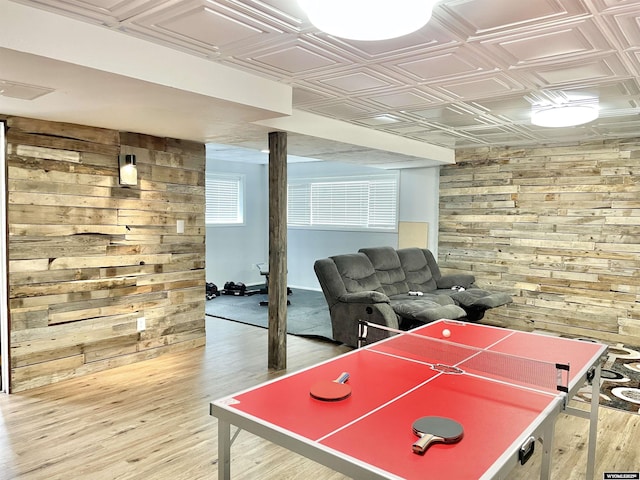 game room featuring wooden walls and light wood-type flooring