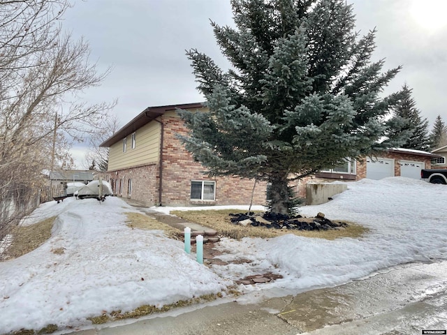 view of snowy exterior featuring a garage