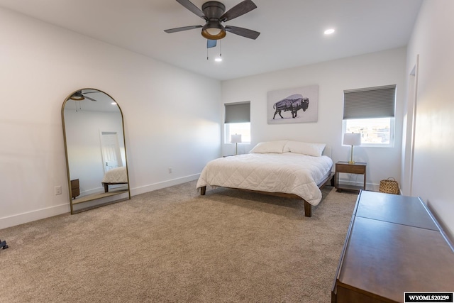 carpeted bedroom featuring ceiling fan and multiple windows