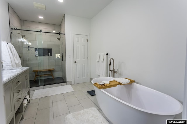 bathroom featuring vanity, plus walk in shower, and tile patterned flooring