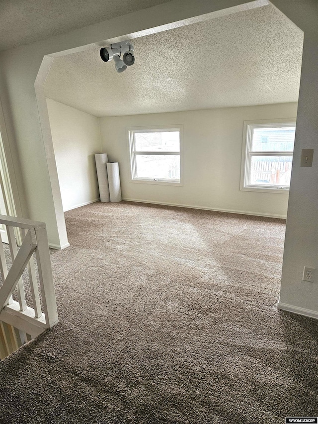 carpeted spare room with a textured ceiling