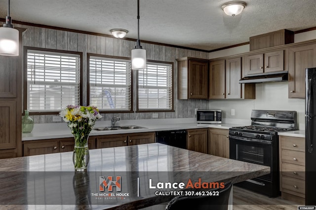 kitchen featuring hanging light fixtures, black appliances, sink, and a textured ceiling
