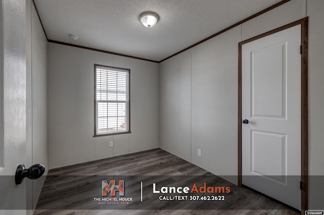empty room featuring ornamental molding, dark hardwood / wood-style floors, and a textured ceiling