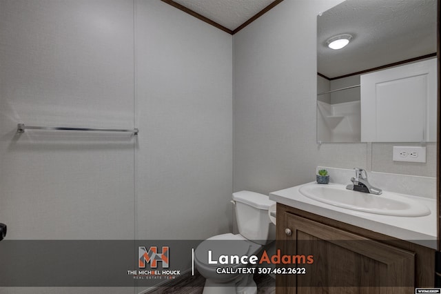 bathroom featuring crown molding, vanity, toilet, and a textured ceiling