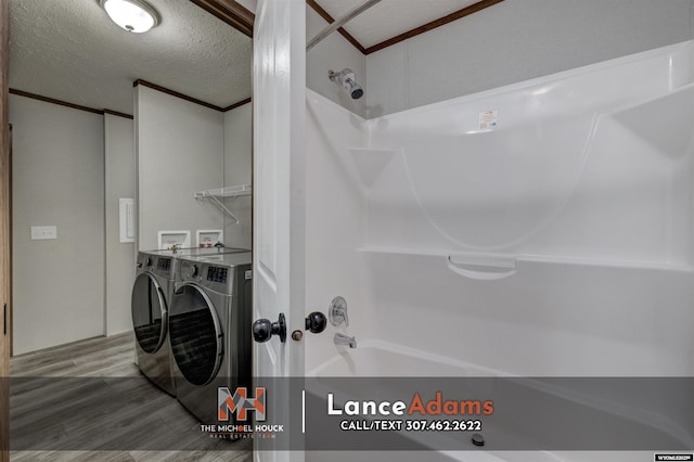 bathroom featuring shower / tub combination, hardwood / wood-style floors, independent washer and dryer, ornamental molding, and a textured ceiling