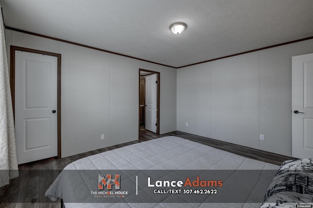 bedroom featuring ornamental molding, dark hardwood / wood-style flooring, and a textured ceiling